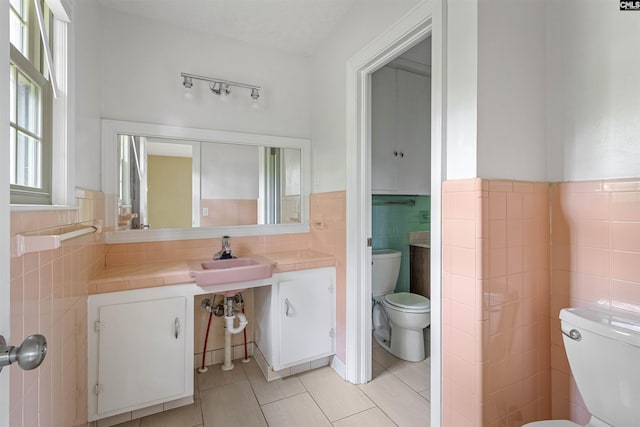 1629 B Ave, West Columbia, SC 29169 - bathroom featuring toilet, tile walls, tile patterned flooring, vanity, and a wainscoted wall
