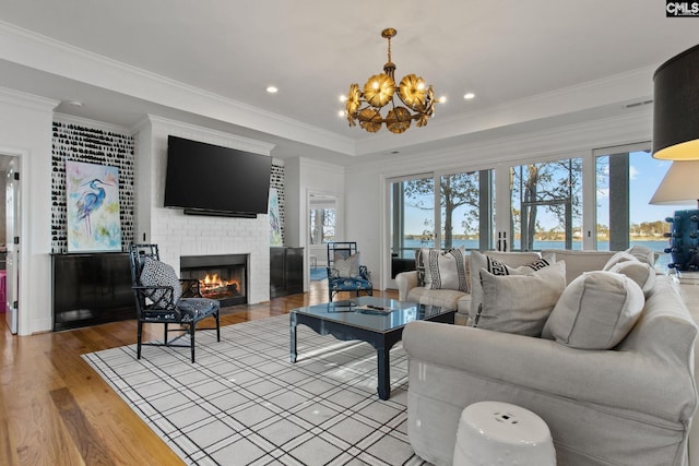 208 Ballentine Ln, Chapin, SC 29036 - living room featuring healthy amount of natural light, a chandelier, a fireplace, wood finished floors, and ornamental molding