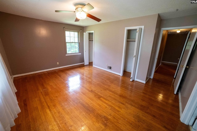 109 Mcrae St, Columbia, SC 29203 - unfurnished bedroom with light wood finished floors, baseboards, two closets, and a ceiling fan