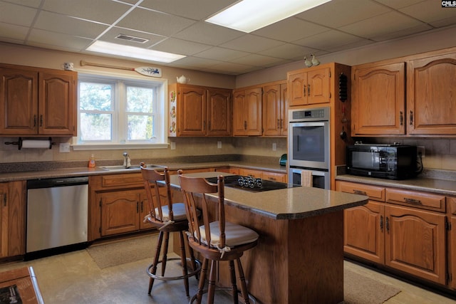 429 Forest Shores Rd, Prosperity, SC 29127 - kitchen with black appliances, a paneled ceiling, a breakfast bar area, a center island, and a sink