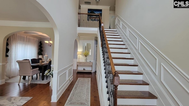 522 Meadow Grass Ln, Lexington, SC 29072 - stairway featuring a decorative wall, arched walkways, wood finished floors, wainscoting, and a towering ceiling