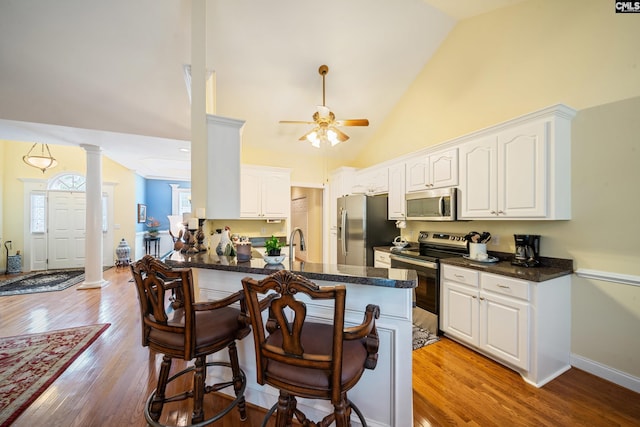 55 Hickory Woods Ct, Columbia, SC 29223 - kitchen featuring stainless steel appliances, decorative columns, dark countertops, high vaulted ceiling, and ceiling fan