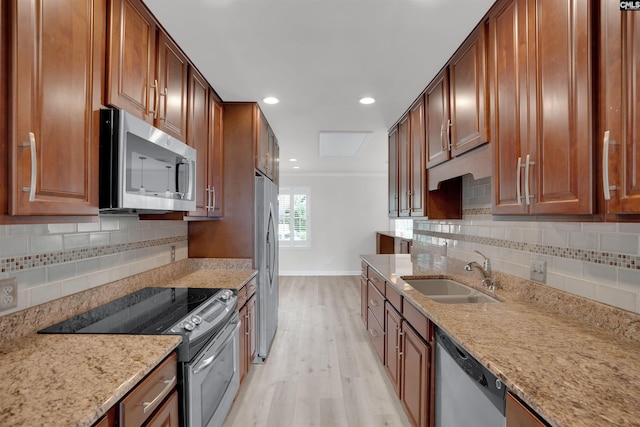 10 Low Hill Ln, Lexington, SC 29072 - kitchen featuring stainless steel appliances, a sink, light wood finished floors, baseboards, and light stone counters