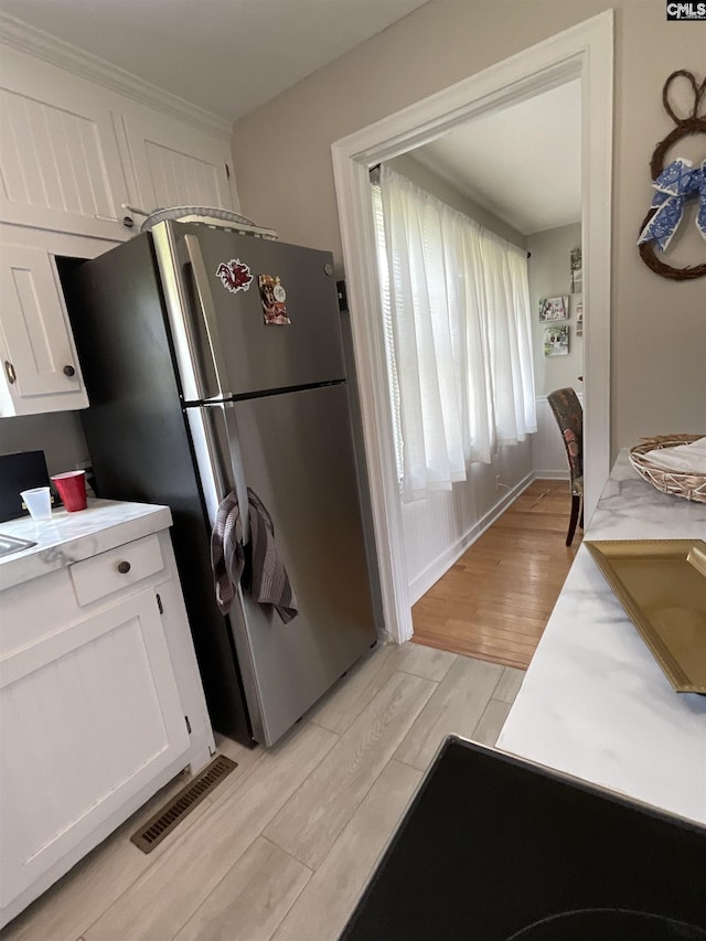 150 Azalea Ave, Bamberg, SC 29003 - kitchen featuring freestanding refrigerator, light wood finished floors, white cabinetry, and light countertops