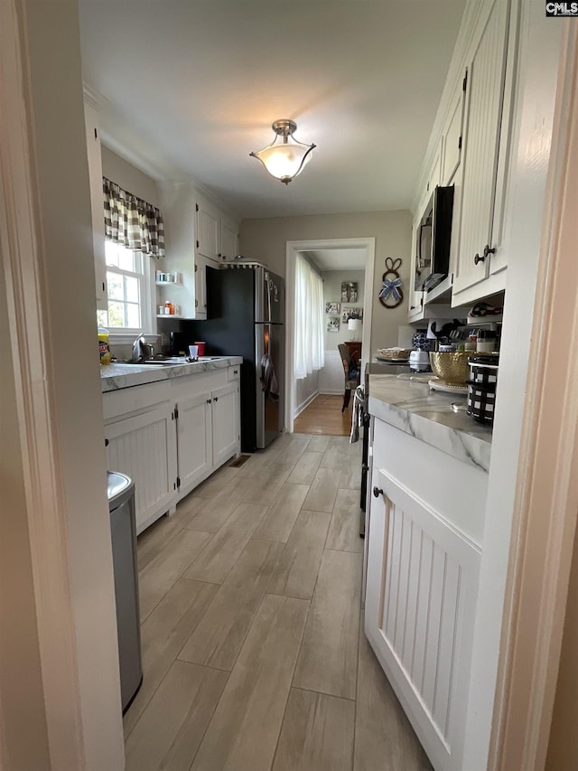 150 Azalea Ave, Bamberg, SC 29003 - kitchen featuring appliances with stainless steel finishes, light wood-style floors, white cabinets, open shelves, and light stone counters