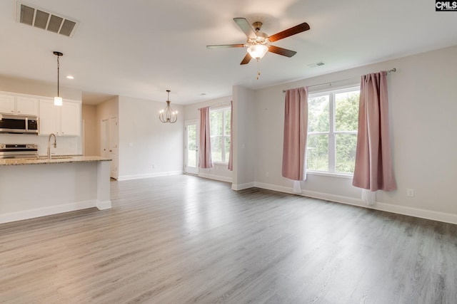 412 Blue Robin Ln, Columbia, SC 29210 - unfurnished living room featuring a chandelier, a ceiling fan, light wood-type flooring, baseboards, and recessed lighting