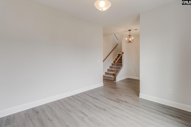412 Blue Robin Ln, Columbia, SC 29210 - empty room with wood finished floors, stairs, baseboards, and a chandelier