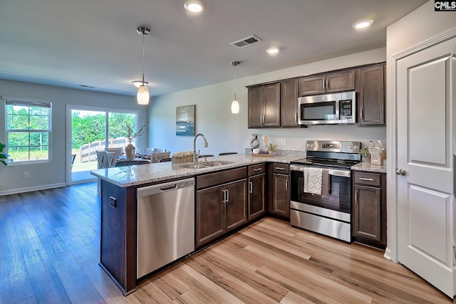 2426 Trakand Dr, Lexington, SC 29073 - kitchen with appliances with stainless steel finishes, a sink, a peninsula, dark brown cabinetry, and recessed lighting