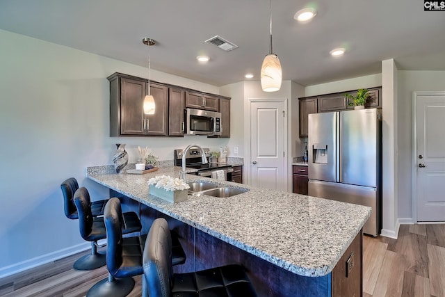 2426 Trakand Dr, Lexington, SC 29073 - kitchen with appliances with stainless steel finishes, baseboards, a peninsula, dark brown cabinets, and recessed lighting