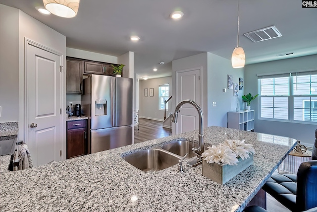 2426 Trakand Dr, Lexington, SC 29073 - kitchen with stainless steel fridge with ice dispenser, a sink, wood finished floors, dark brown cabinetry, and light stone countertops