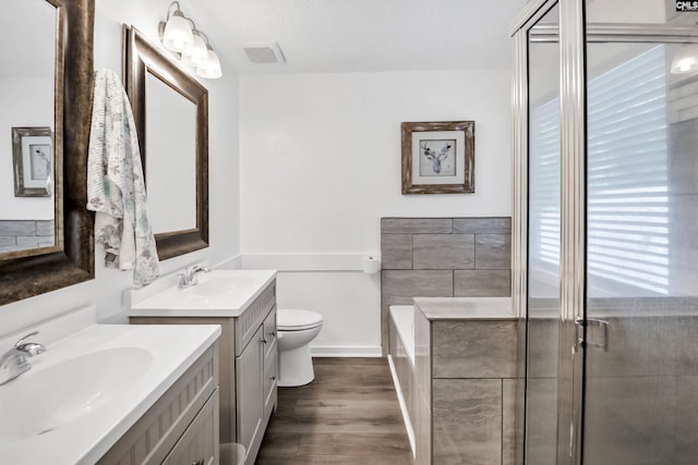219 Sparkleberry Ln, Columbia, SC 29229 - full bath featuring wood finished floors, two vanities, a bath, toilet, and a stall shower