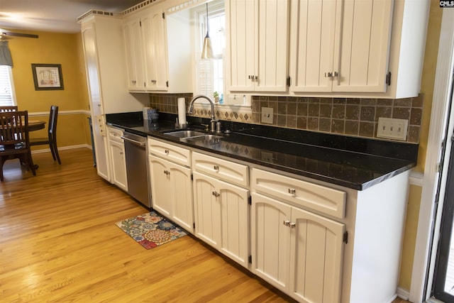 213 River Xing, Lexington, SC 29072 - kitchen featuring stainless steel dishwasher, a sink, decorative backsplash, light wood-type flooring, and dark countertops