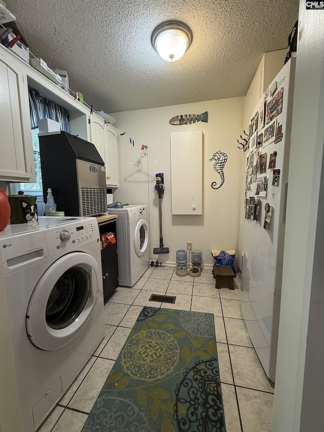 213 River Xing, Lexington, SC 29072 - laundry room featuring washer and clothes dryer, cabinet space, a textured ceiling, and light tile patterned flooring