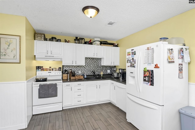 112 S Wrenwood Dr, Lexington, SC 29073 - kitchen with white appliances, a sink, under cabinet range hood, dark countertops, and white cabinets