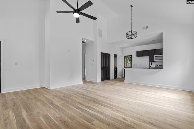 3723 Hoyt St, Columbia, SC 29223 - unfurnished living room featuring light wood-type flooring, ceiling fan, high vaulted ceiling, baseboards, and a chandelier