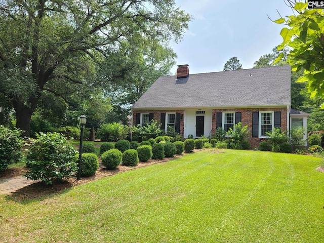 2003 Springdale Dr, Camden, SC 29020 - cape cod house with brick siding, a front yard, a chimney, and a shingled roof
