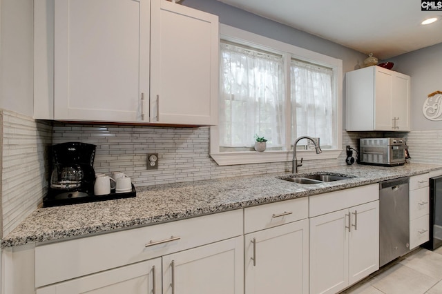 4524 Mosshill Rd, Columbia, SC 29206 - kitchen with a sink, dishwasher, white cabinets, tasteful backsplash, and light stone countertops