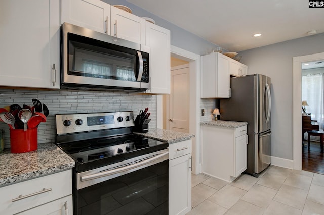 4524 Mosshill Rd, Columbia, SC 29206 - kitchen with stainless steel appliances, backsplash, white cabinets, light tile patterned floors, and light stone countertops