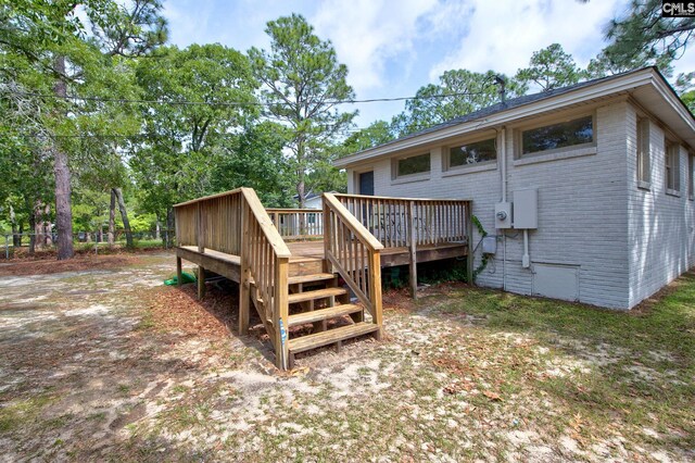 4524 Mosshill Rd, Columbia, SC 29206 - rear view of house featuring brick siding, a wooden deck, and view of scattered trees