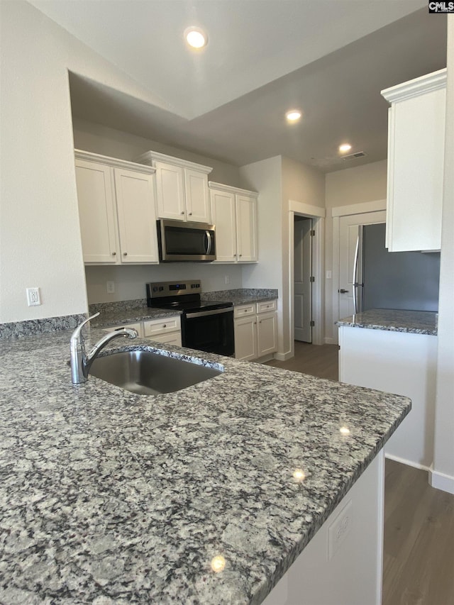 5 Graceful Doe Ct, Elgin, SC 29045 - kitchen with appliances with stainless steel finishes, a sink, white cabinets, dark stone counters, and recessed lighting