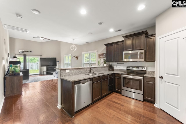 300 Brookland Way W, Columbia, SC 29169 - kitchen with stainless steel appliances, a sink, dark brown cabinets, a peninsula, and wood finished floors