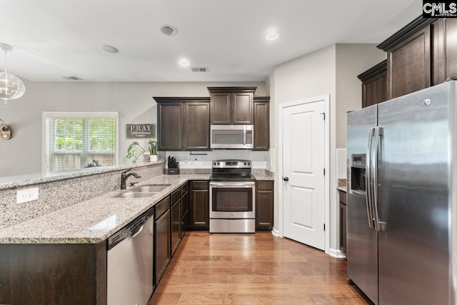 300 Brookland Way W, Columbia, SC 29169 - kitchen featuring stainless steel appliances, a sink, dark brown cabinets, light wood-style flooring, and a peninsula