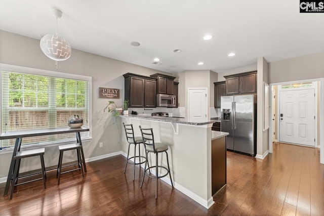 300 Brookland Way W, Columbia, SC 29169 - kitchen featuring appliances with stainless steel finishes, dark brown cabinetry, light stone countertops, a peninsula, and recessed lighting
