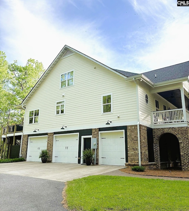 166 Sawney Creek Cir, Ridgeway, SC 29130 - view of side of home featuring an attached garage, asphalt driveway, brick siding, and a balcony