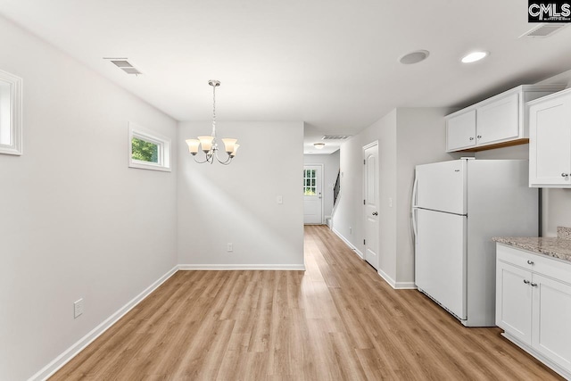 337 Gum Swamp Trl, West Columbia, SC 29169 - kitchen with freestanding refrigerator, light wood-style floors, white cabinets, a chandelier, and baseboards