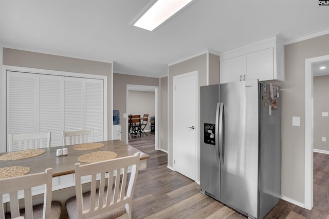 1620 Deep Cove Ln, Gilbert, SC 29054 - kitchen with stainless steel fridge, light wood-type flooring, crown molding, white cabinetry, and baseboards