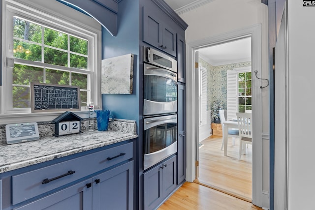 22 Mallet Hill Ct, Columbia, SC 29223 - kitchen with stainless steel double oven, ornamental molding, light wood-type flooring, blue cabinets, and light stone countertops