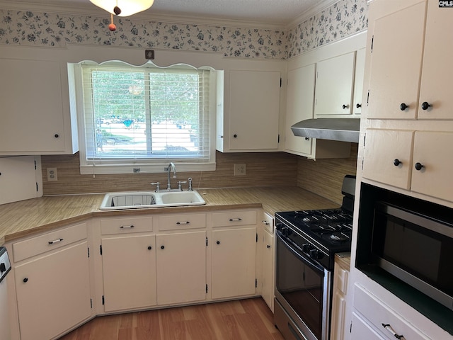 1147 Gunter Cir, West Columbia, SC 29169 - kitchen with gas range, a sink, under cabinet range hood, stainless steel microwave, and decorative backsplash