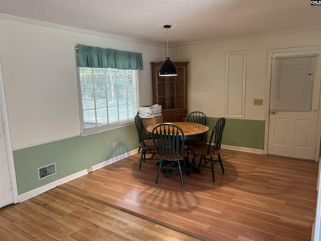 1147 Gunter Cir, West Columbia, SC 29169 - dining room with wood finished floors, ornamental molding, a textured ceiling, and baseboards
