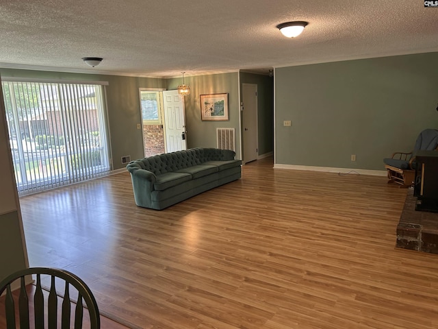1147 Gunter Cir, West Columbia, SC 29169 - living room featuring crown molding, a textured ceiling, light wood-type flooring, and baseboards