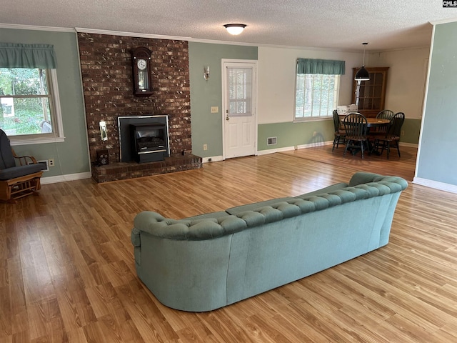 1147 Gunter Cir, West Columbia, SC 29169 - living room featuring a textured ceiling, wood finished floors, crown molding, a brick fireplace, and baseboards