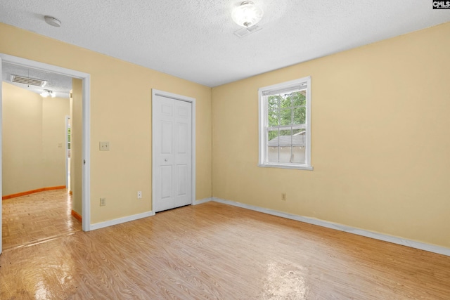 114 Quattlebaum Ave, Ridge Spring, SC 29129 - unfurnished bedroom featuring light wood-type flooring, a textured ceiling, baseboards, and a closet