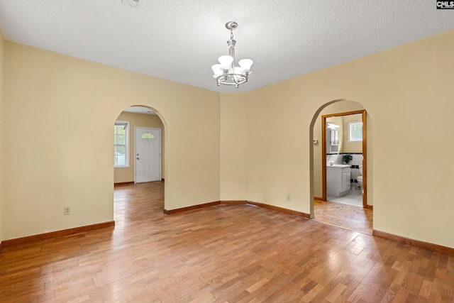 114 Quattlebaum Ave, Ridge Spring, SC 29129 - empty room featuring arched walkways, a chandelier, light wood-type flooring, and baseboards