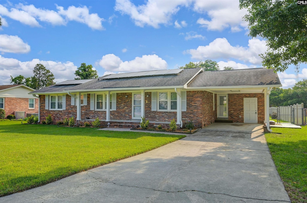 1129 Starcrest Dr, West Columbia, SC 29172 - single story home with driveway, a porch, brick siding, solar panels, and a shingled roof