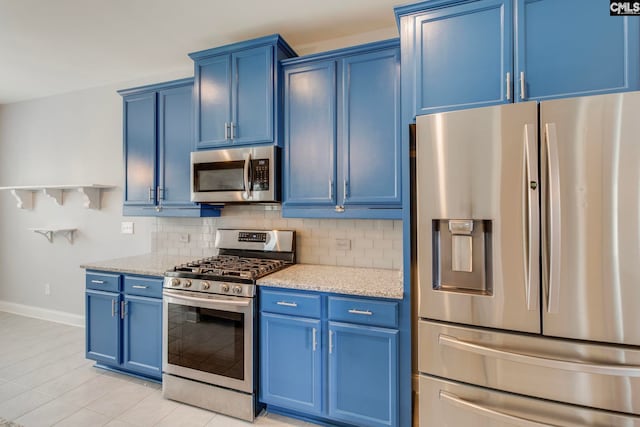 571 Maple Valley Loop, Blythewood, SC 29016 - kitchen with stainless steel appliances, blue cabinetry, baseboards, decorative backsplash, and light tile patterned flooring