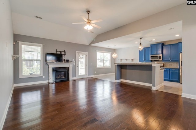 571 Maple Valley Loop, Blythewood, SC 29016 - unfurnished living room featuring dark wood finished floors, baseboards, ceiling fan, vaulted ceiling, and a glass covered fireplace
