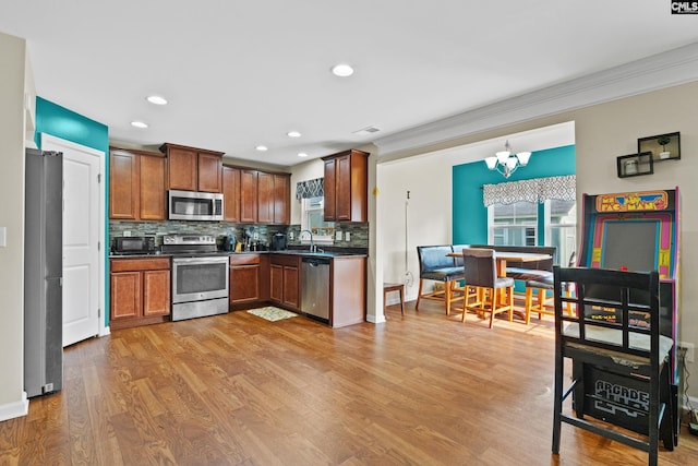 17 Cypress Cove Rd, Columbia, SC 29229 - kitchen with stainless steel appliances, a sink, dark countertops, tasteful backsplash, and a chandelier