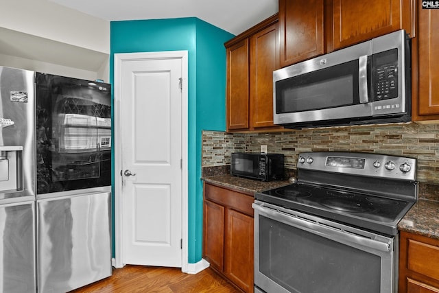 17 Cypress Cove Rd, Columbia, SC 29229 - kitchen featuring appliances with stainless steel finishes, decorative backsplash, wood finished floors, dark stone counters, and brown cabinetry