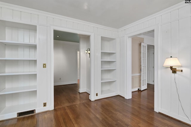 723 Hampton Hill Rd, Columbia, SC 29209 - spare room featuring built in features, crown molding, baseboards, dark wood-type flooring, and a decorative wall
