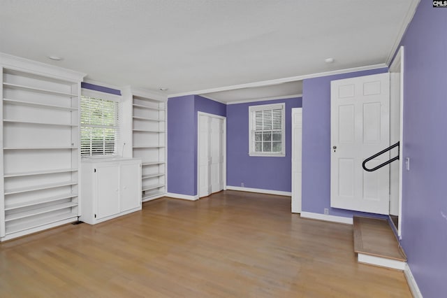 723 Hampton Hill Rd, Columbia, SC 29209 - unfurnished living room featuring wood finished floors, baseboards, crown molding, and built in shelves