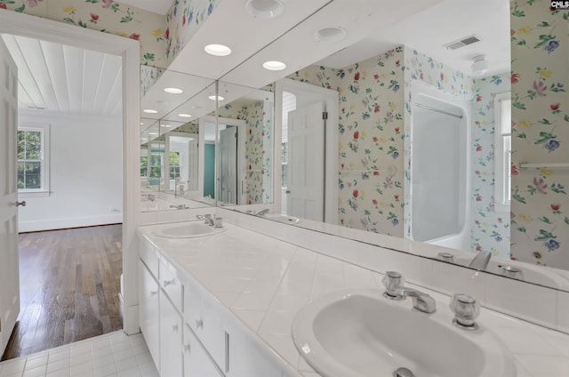 723 Hampton Hill Rd, Columbia, SC 29209 - bathroom featuring wallpapered walls, double vanity, baseboards, and wood finished floors