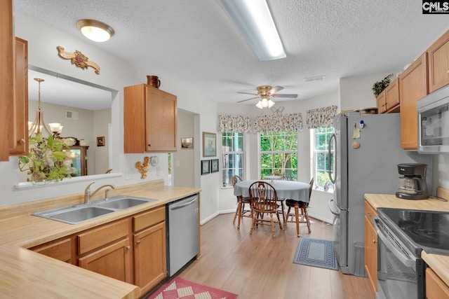 24 Stoney Pointe Dr, Chapin, SC 29036 - kitchen with appliances with stainless steel finishes, a sink, a textured ceiling, light countertops, and light wood-type flooring