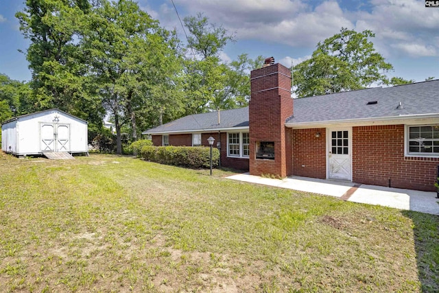 1109 F Ave, Cayce, SC 29033 - back of property featuring a chimney, a lawn, a shingled roof, brick siding, and a patio area