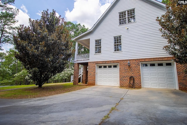 2492 Harbor View Rd, Camden, SC 29020 - view of side of home with concrete driveway, an attached garage, brick siding, and a balcony