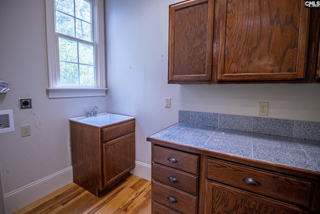 2492 Harbor View Rd, Camden, SC 29020 - washroom featuring hookup for an electric dryer, washer hookup, cabinet space, light wood-type flooring, and baseboards