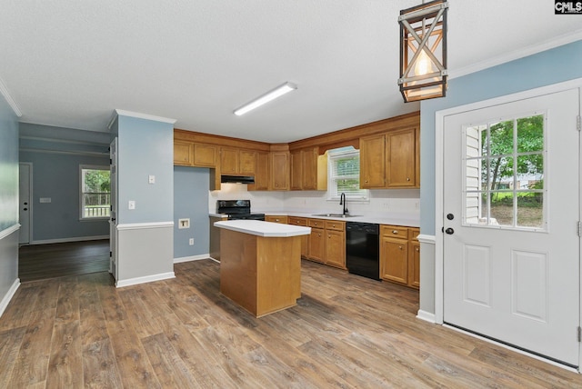 1149 Pond Branch Rd, Gilbert, SC 29054 - kitchen with black appliances, a center island, under cabinet range hood, ornamental molding, and brown cabinets